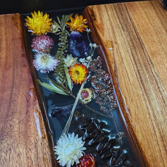Decorative tray with pressed flowers and leaves on a wooden surface